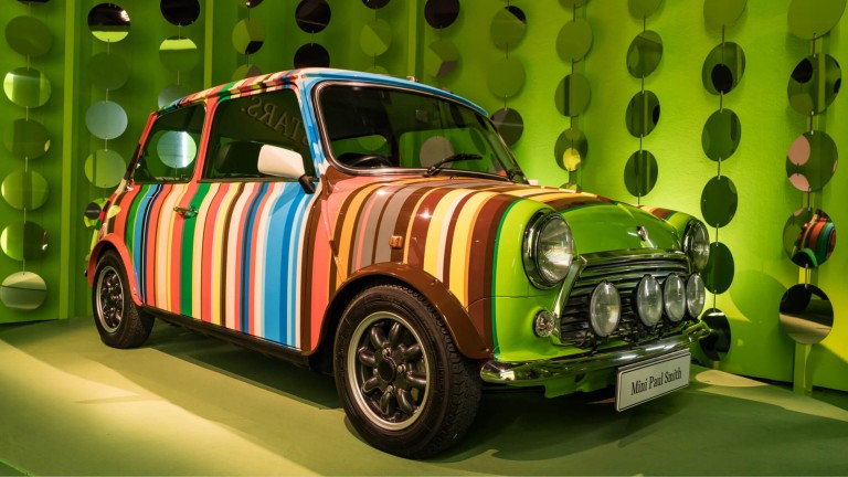 A vintage MINI painted with vertical rainbow stripes