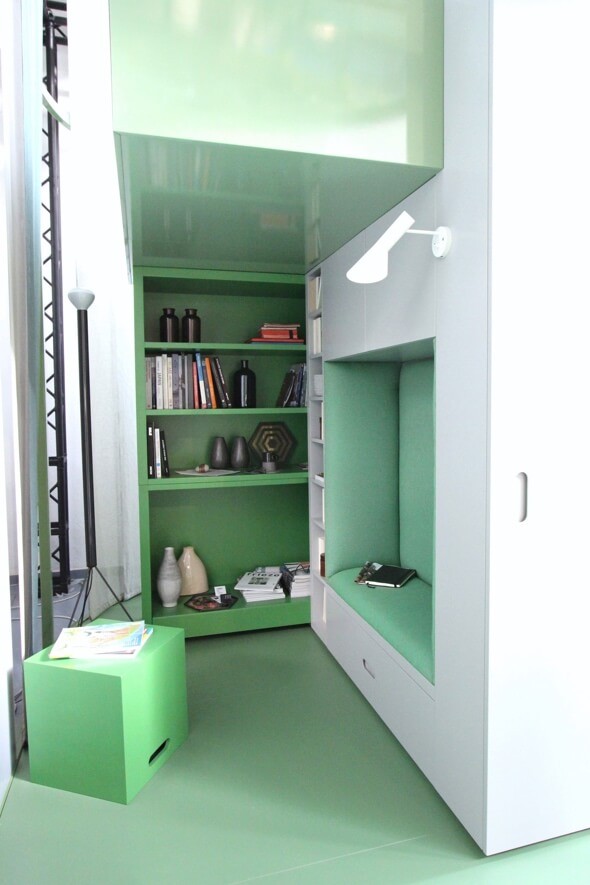 Minimal study in green with books, reading nook and light
