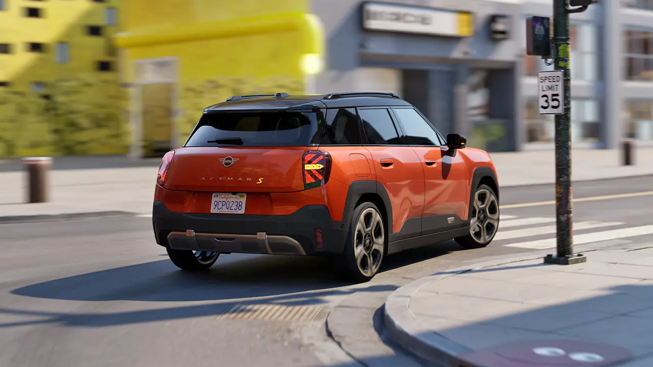 In motion, the first-ever all-electric MINI Aceman stands out against an abstract, colourful background.