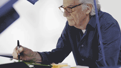A gif of Paul Smith signing the lime green battery of his converted MINI Recharged model. 