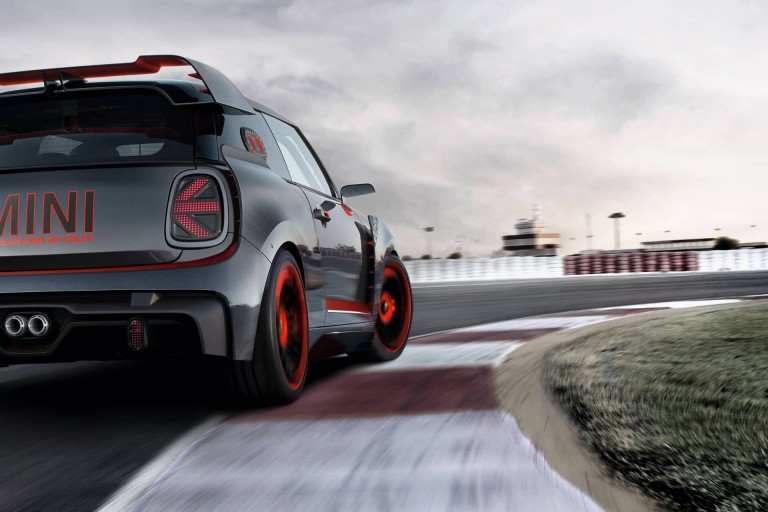 A red and black MINI John Cooper Works Concept is seen from behind on a race track.