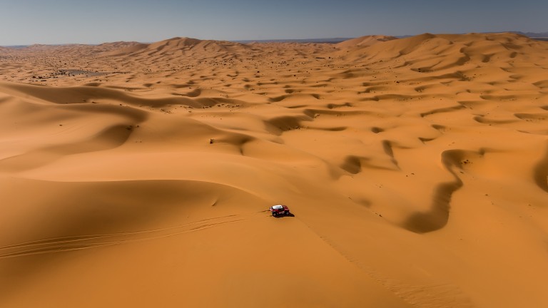 Spectacular overhead view of the lone MINI John Cooper Works Buggy driving across the desert at Dakar Rally 2018.