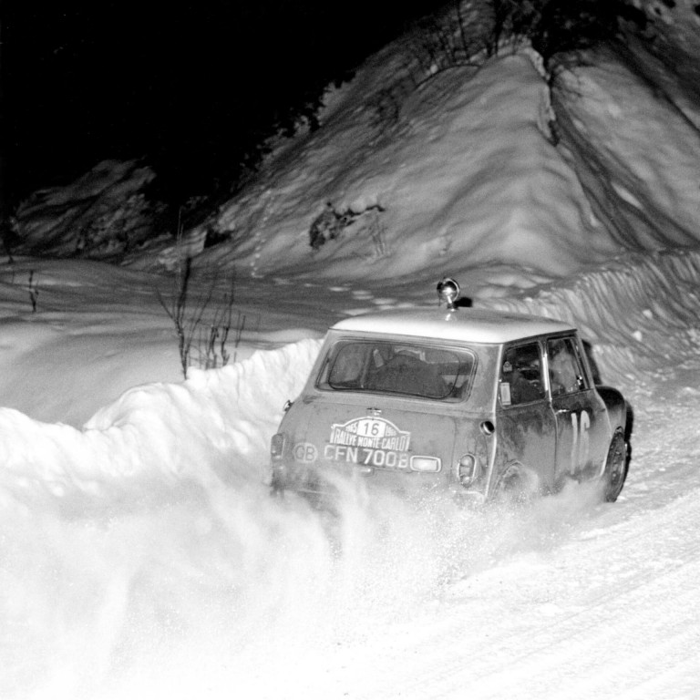 BMC Works Mini Cooper S speeds away leaving a cloud of snow behind it at the 1965 Monte Carlo Rally.
