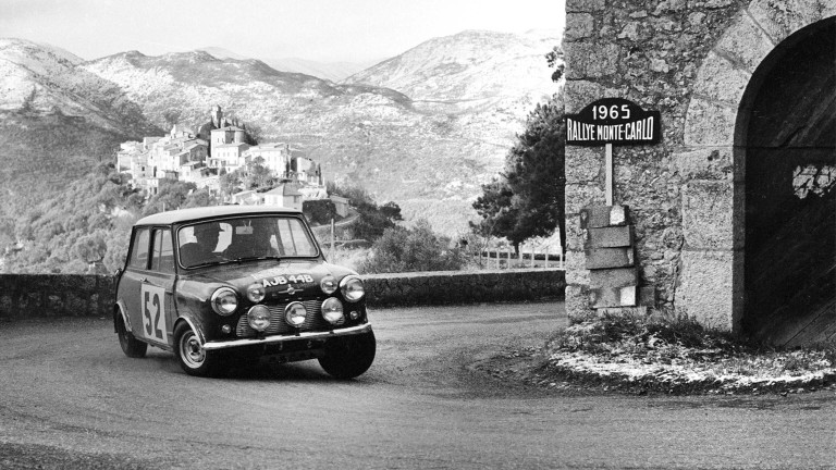BMC Works Mini Cooper S speeds around a turn at the 1965 Monte Carlo Rally.