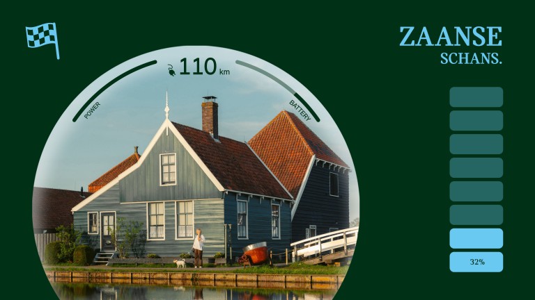 Katarina and Paya the dog pictured across the water and in front of a traditional wooden home in Zaanse Schans.