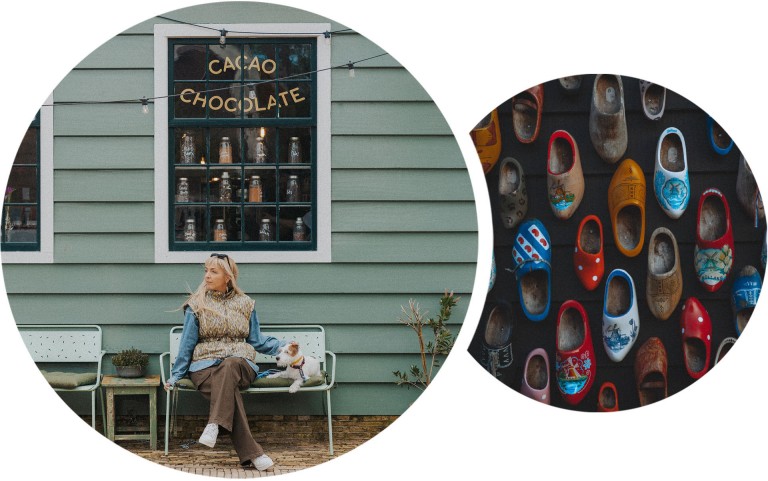 Katarina and Paya the dog sit on a small bench, in front of a chocolate shop in Zaanse Schans. Up-close photograph of colourful traditional clogs in a variety of designs hung on a wall.