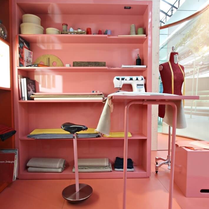 Little, pink sewing room with a bicycle seat stool