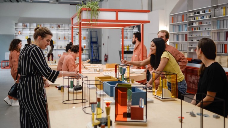 Men and women using colourful building blocks and black frames to design new living spaces.