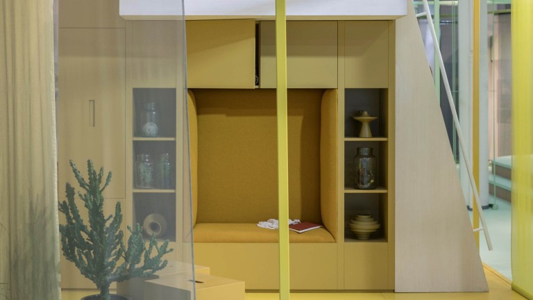 Small living room in yellow with a reading nook build into the wall cabinets