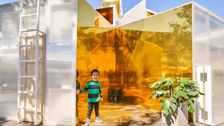 Young visitor fascinated by the mirror-clad walls of the MINI LIVING Urban Cabin in Beijing