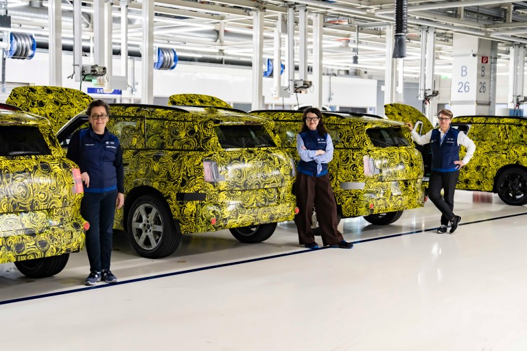 Sonja Hengstler (Project Manager for the new MINI Countryman), Stefanie Wurst (Head of MINI) and Petra Peterhaensel (Plant Director in Leipzig) in one of the production halls in Leipzig. Each standing next to a Countryman model. 