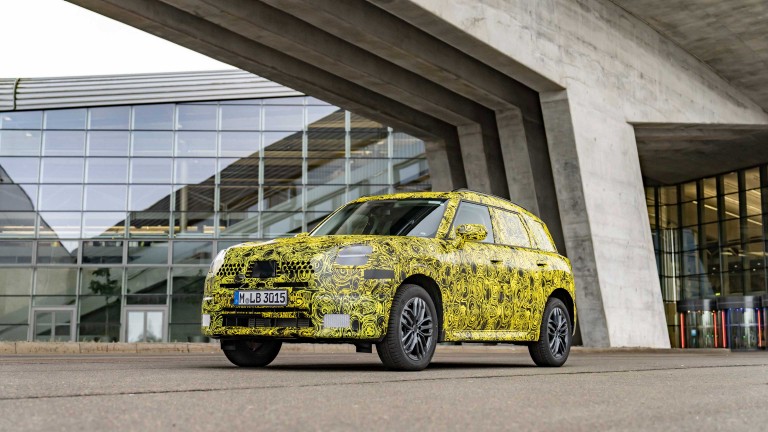A camouflaged model of the new MINI Countryman in front of the BMW Group plant in Leipzig.