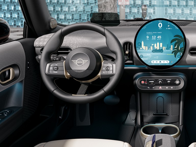 View of the interior of the new MINI Cooper Convertible, focusing on the steering wheel and round OLED display.