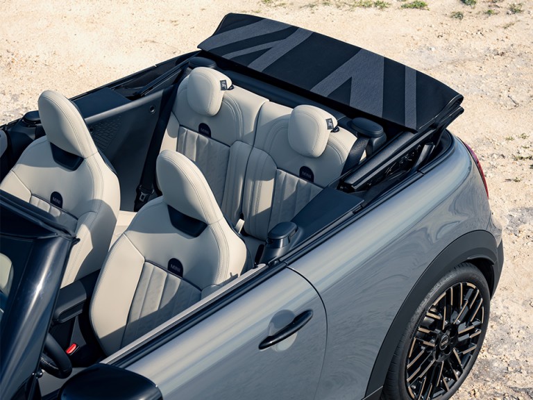 Angled overhead shot of the new MINI Cooper Convertible with an open top, offering a view of the sportive seating.