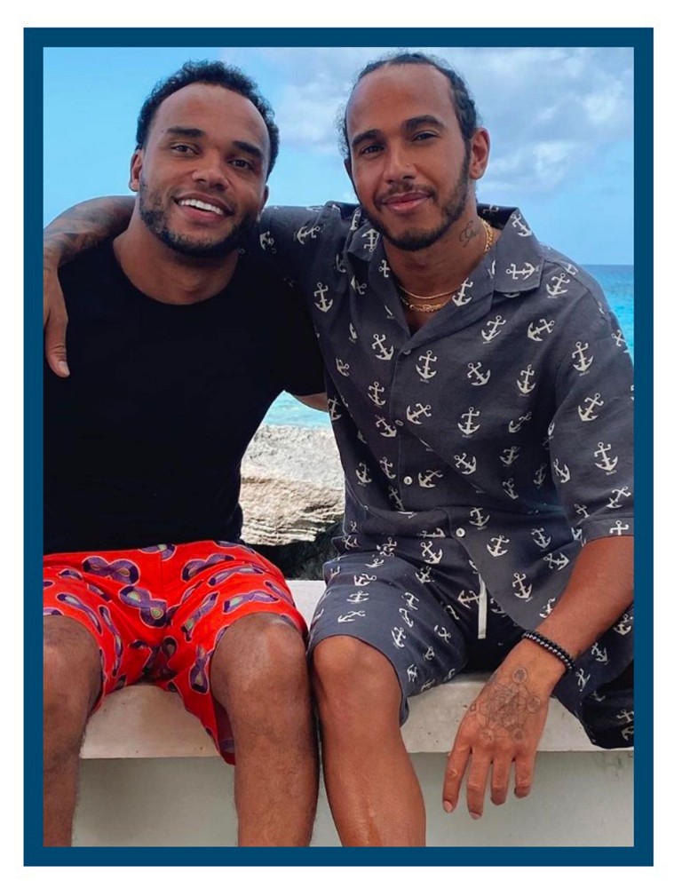 Image of Nicolas and his brother Lewis Hamilton. They embrace, sitting and looking friendly into the camera. 