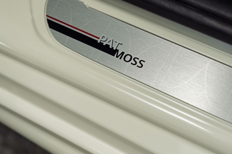 Close-up of the silver car door sill trim with a red and black Pat Moss labeling and dynamic stripe elements. 