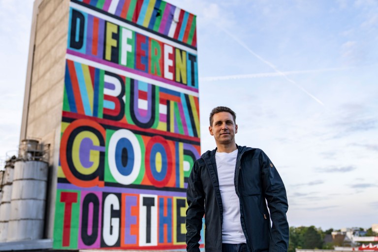 Bernd Körber, Head of MINI, in front of MINI's Big Love mural at the IAA in 2021.
