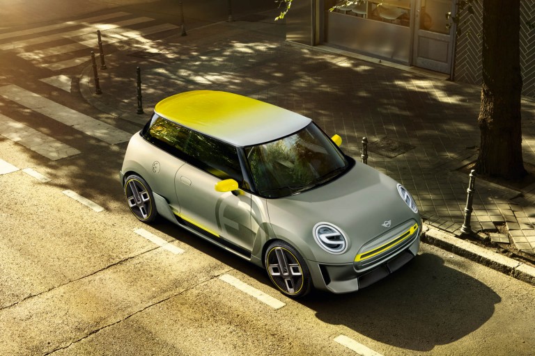 The silver and yellow MINI Electric Concept car, shown from above, parked in a sunny city street.