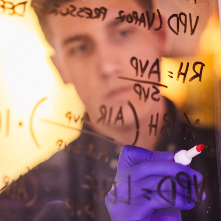 Man is writing on a glass. 